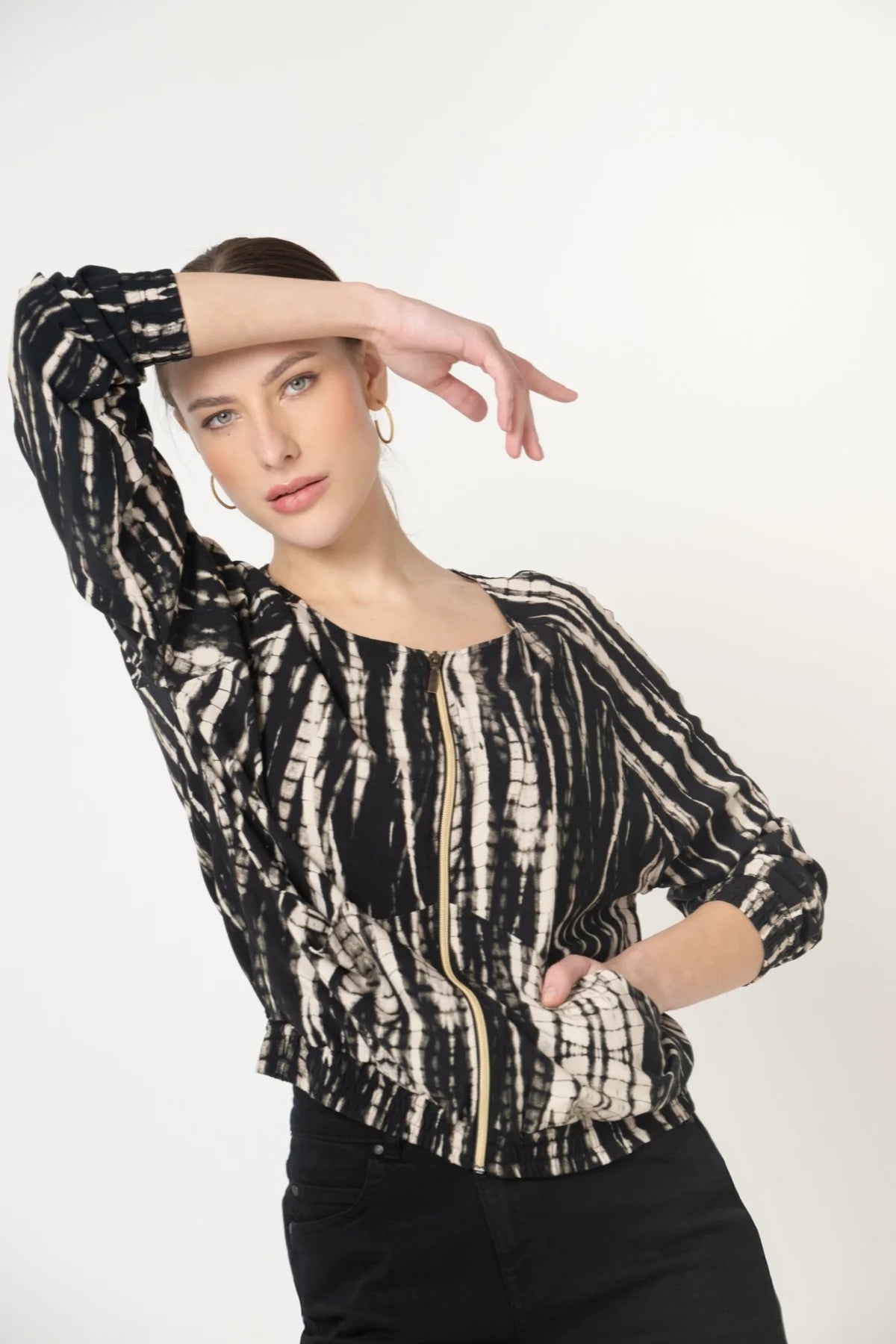 Frau von vorne mit nachhaltiger Blouson Jacke aus Ecovero Viskose in Batik Optik und fair produzierter Jeans in Schwarz.