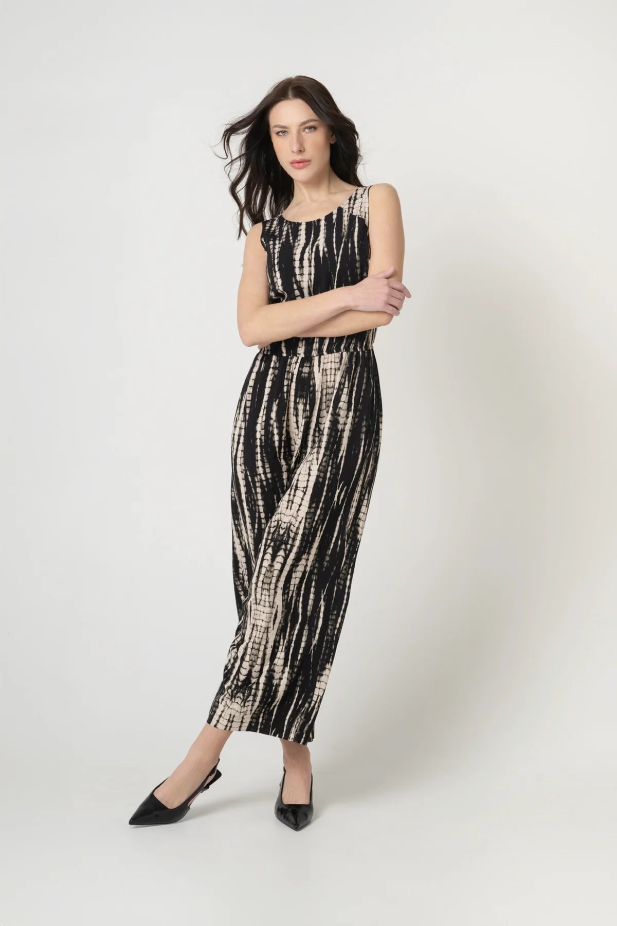 Frau von vorne mit verschränkten Armen mit nachhaltigem Jumpsuit aus Ecovero Viskose in Batik Optik mit Gummizug an der Taille. 