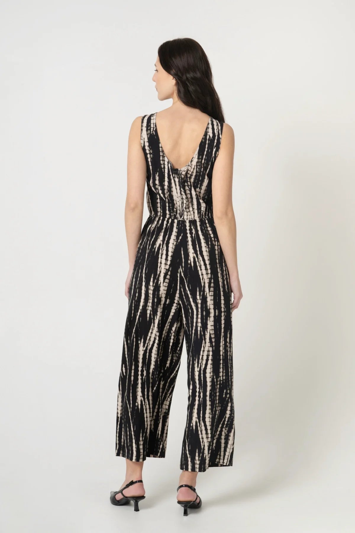 Frau von hinten mit nachhaltigem Jumpsuit aus Ecovero Viskose in Batik Optik mit Gummizug an der Taille. 
